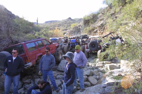 1994 Ford Bronco - A group of off-road vehicles navigate a challenging rocky terrain on a sunny day.