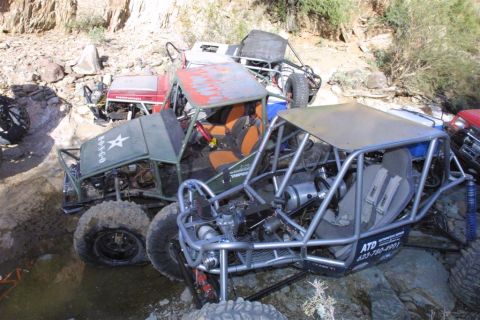 1994 Ford Bronco - Multiple off-road vehicles are entangled in a challenging, rocky terrain, suggesting a difficult off-road excursion.