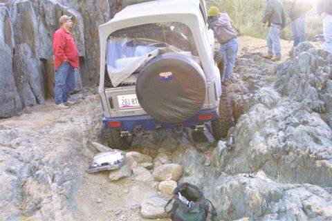 1994 Ford Bronco - Suzuki Samurai attempts a difficult off-road climb on a rocky path with several people watching.