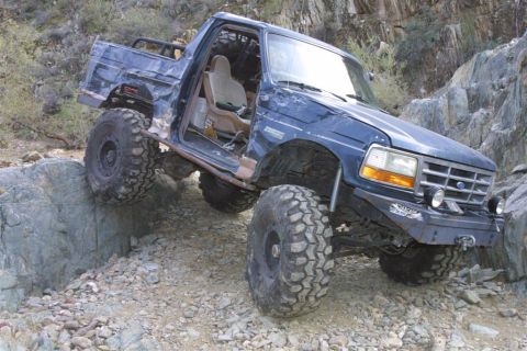 1994 Ford Bronco - This modified 1994 Ford Bronco navigates a rocky trail with its large off-road tires.