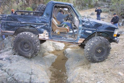 1994 Ford Bronco - This heavily modified Ford Bronco navigates a rocky trail with its doors off.