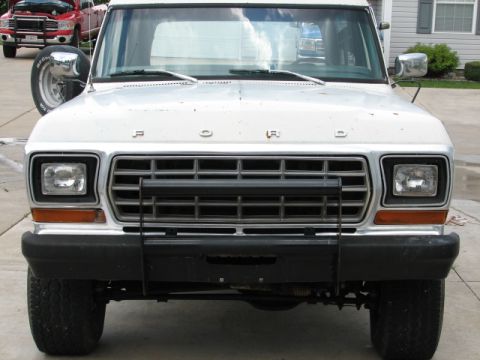 1979 Ford Bronco - A white Ford Bronco is parked in front of a house, with another vehicle in the background.