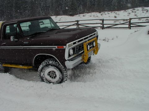 1979 Ford Bronco - Ford Bronco with brush guard navigating a snowy landscape.