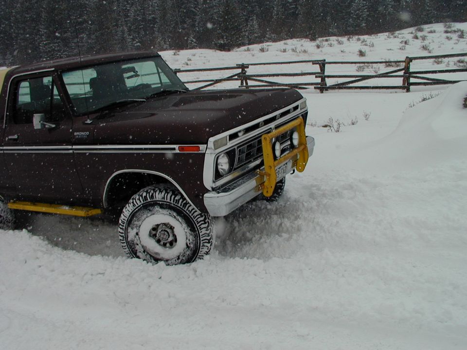 1978 Ford Bronco with yellow brush guard driving in snow