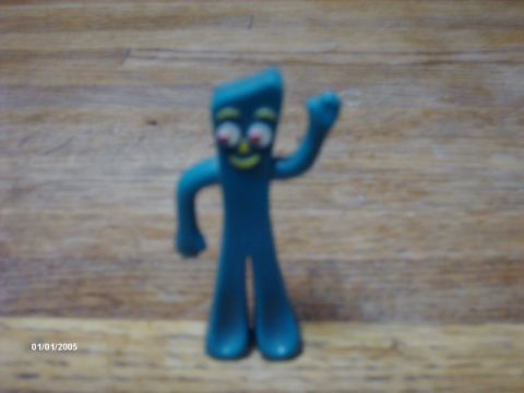 1995 Ford Probe - A blue Gumby figurine stands on a wooden surface, waving with one arm.
