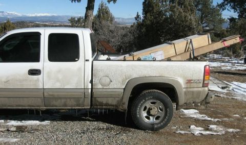 1990 Ford Bronco - White pickup truck loaded with lumber, parked outdoors in a snowy, rural setting.