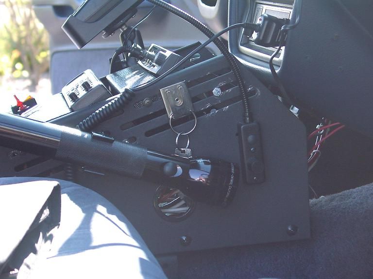Vehicle interior console with mounted flashlight, keys, and radio equipment