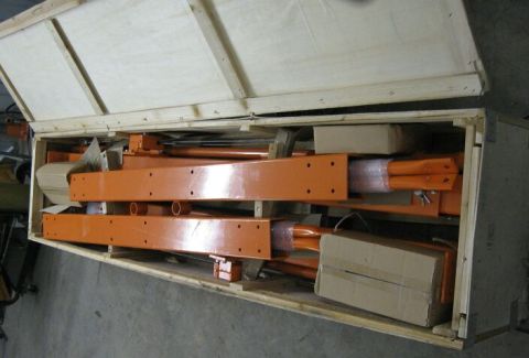 1990 Ford Bronco - The crate contains several large, orange, metal components, possibly parts for machinery or construction.