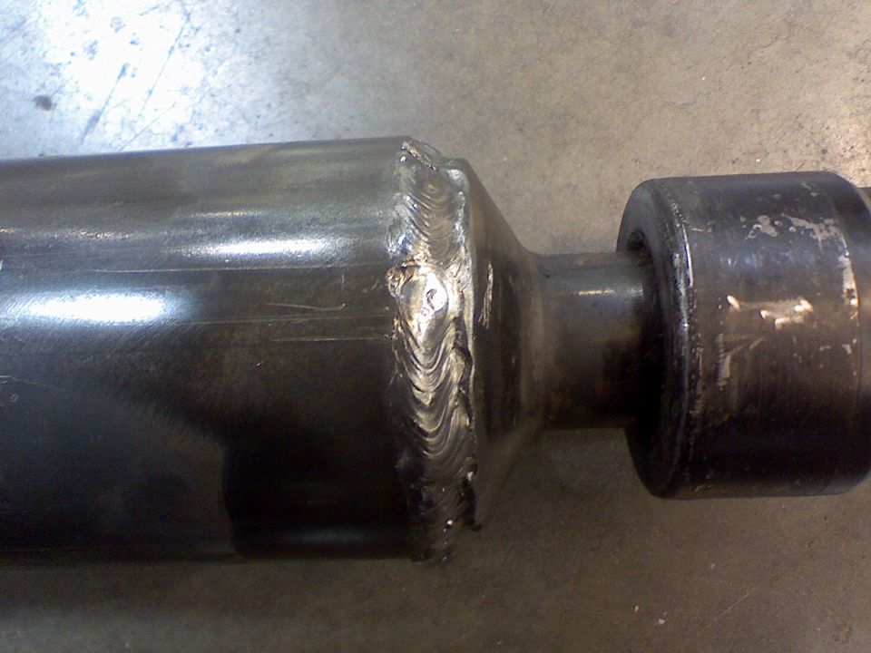 Close-up of a drive shaft with rough welds on a metal surface