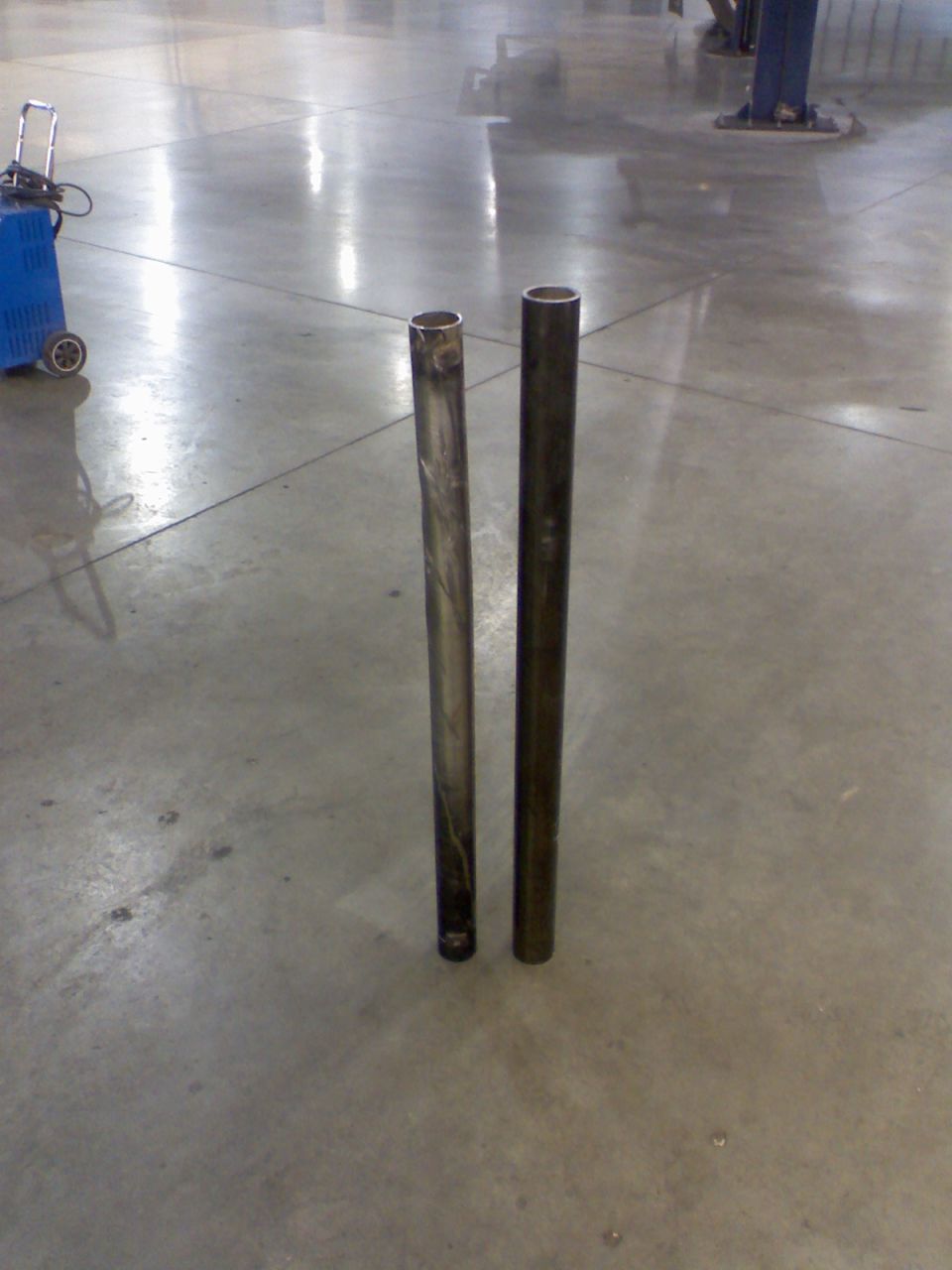 Two metal pipes on a concrete floor