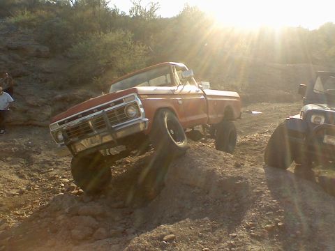 1974 Ford F-250 - Red Ford pickup truck navigating rough terrain off-road.