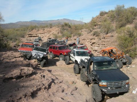 1974 Ford F-250 - A convoy of off-road vehicles makes its way through a challenging desert terrain.