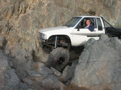 1974 Ford F-250 - A white pickup truck maneuvers through a challenging rocky off-road course.