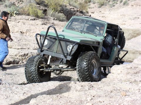 1986 Toyota Hilux - This modified off-road vehicle is shown navigating a challenging rocky path.