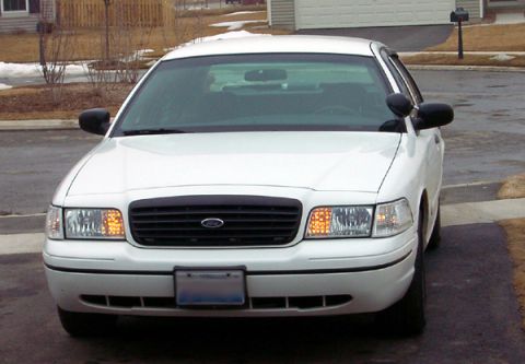 1999 Ford Crown Victoria - This white Ford Crown Victoria is shown from the front, with its headlights and grille clearly visible.