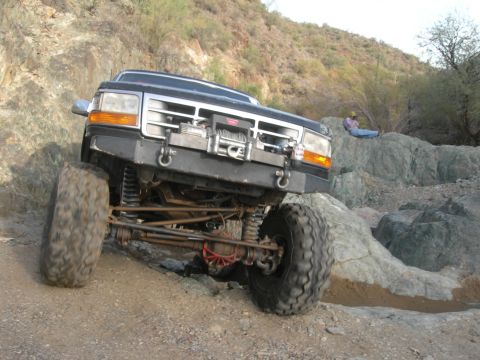 1974 Ford F-250 - A modified Ford F-Series truck navigates a challenging rocky trail, demonstrating its off-road capabilities.
