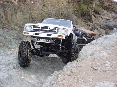 1986 Toyota Hilux - This modified 1986 Toyota Hilux navigates a rocky trail, its impressive off-road capabilities.