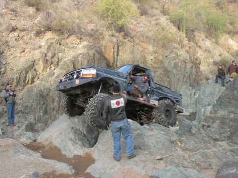 1974 Ford F-250 - Pickup truck attempts to climb a steep, rocky incline off-road.
