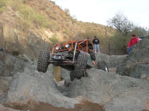 1974 Ford F-250 - Custom off-road buggy tackles a challenging rocky obstacle during an event.