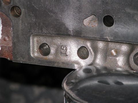 1980 Ford Bronco - Close-up of a cast metal engine block part with stamped markings.