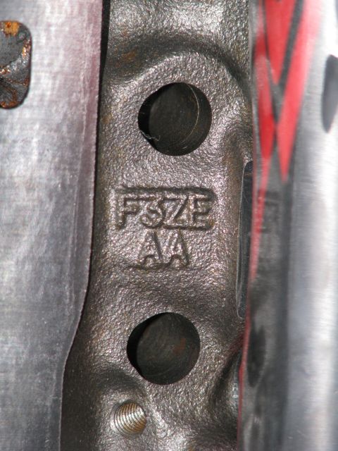 1980 Ford Bronco - Cast metal part with stamped markings 'FSZE AA' and two circular openings.