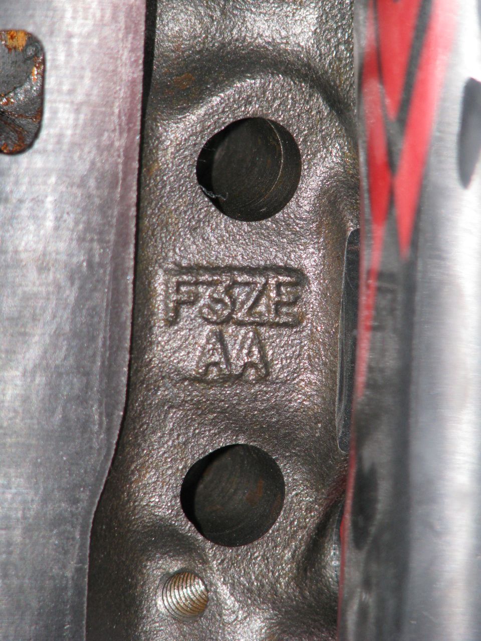 Close-up of cast metal part with 'FSZE AA' stamped on it