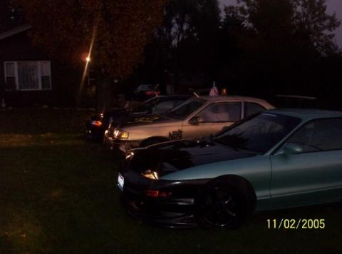 1993 Mercury Topaz - Several cars are parked on the grass in front of a house at twilight. A date stamp shows 11/02/2005.