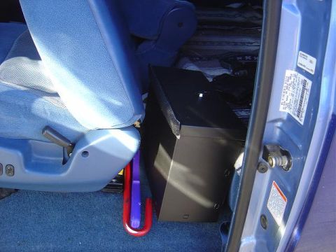 1986 Ford Bronco II - A view inside a blue vehicle, focusing on the seats and a black box positioned between them.