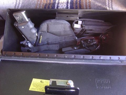 1986 Ford Bronco II - Metal storage box contains two handguns, magazines, and holsters.