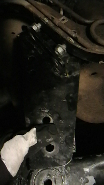 1995 Ford Bronco - A close-up view of a vehicle's suspension bracket, showing bolted connections and some surface wear.