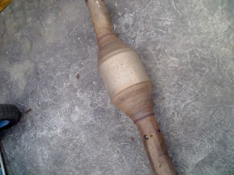 1971 Ford Bronco - Catalytic converter part shown on a concrete surface.
