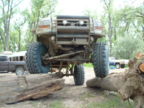 1992 Ford F-350 - A lifted 1992 Ford F-350 truck navigates an obstacle course with large off-road tires.