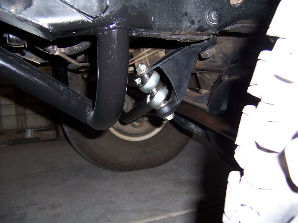 Undercarriage view of suspension and tire with black roll cage tubing