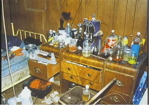 1995 Ford Mustang - A cluttered dresser top is filled with various bottles and jars, next to a bed and a weighing scale.