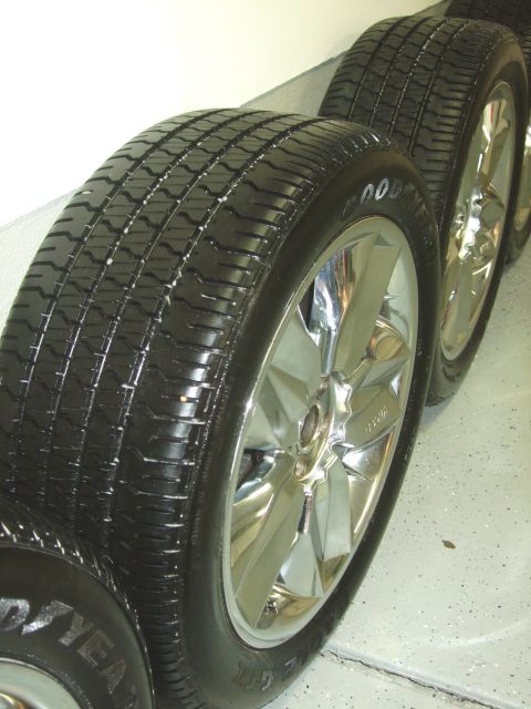 1987 Ford Bronco - Set of four chrome wheels and tires, likely aftermarket parts.