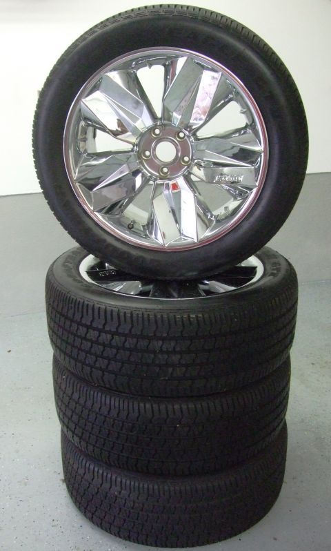 1987 Ford Bronco - A stack of four tires is shown, with a single chrome rim wheel placed on top.
