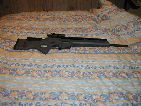 1993 Ford Bronco - A sniper rifle is shown resting on a comforter with a floral pattern.