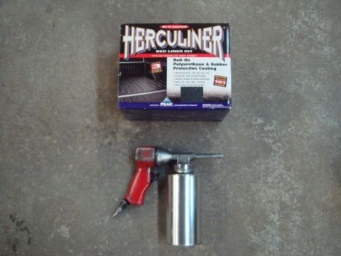 1996 Ford Bronco - Herculiner bed liner kit and an air sprayer are shown on a concrete floor.