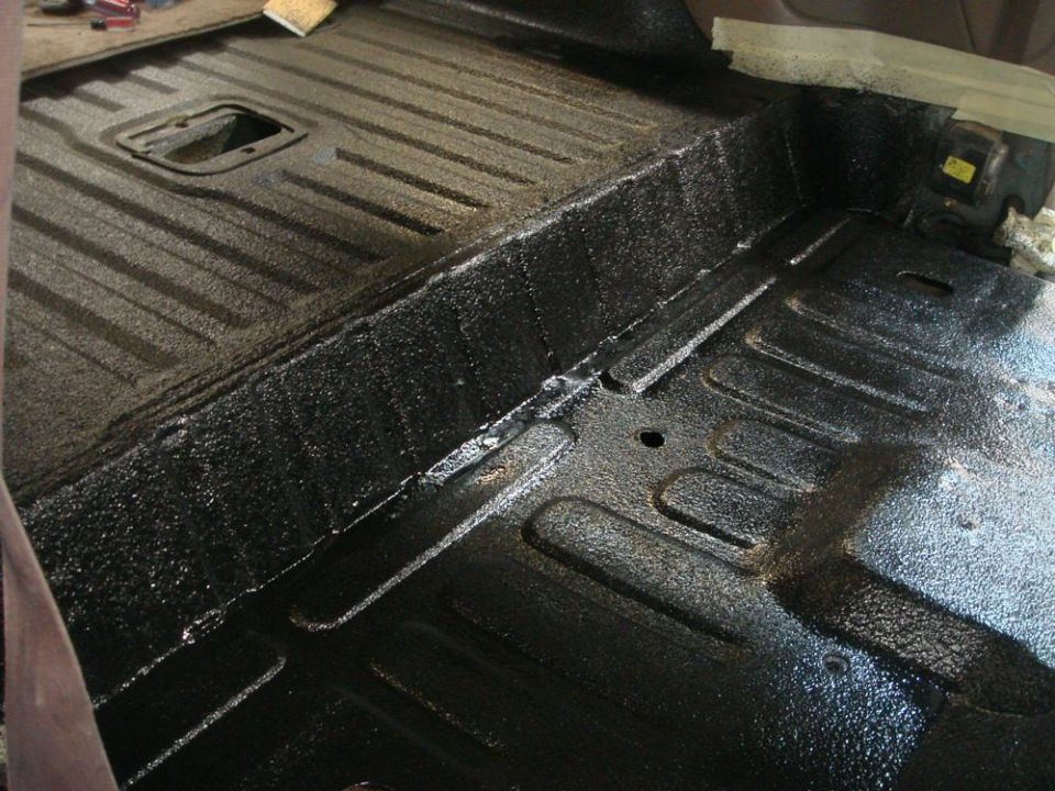 Black textured vehicle floor with ribbed sections and a central rectangular cutout