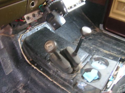 1979 Ford Bronco - Dual shifter levers and cup holder visible in the vehicle's interior floor console.