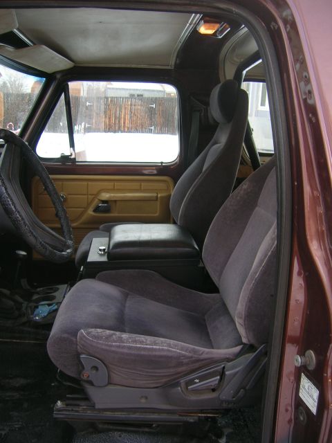 1979 Ford Bronco - The interior of a 1979 Ford Bronco features cloth seats and a center console with a storage compartment.