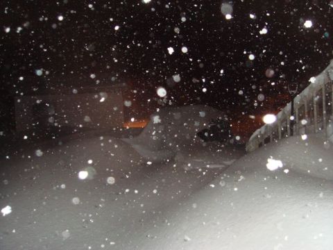 1996 Ford Bronco - A vehicle is almost completely covered by snow during a heavy snowfall at night.