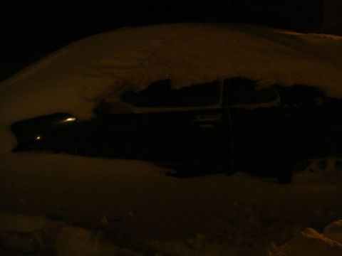 1996 Ford Bronco - A car is completely covered in snow, obscuring its make and model.
