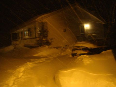 1996 Ford Bronco - A house and a snow-covered car are visible during a heavy snowfall at night.