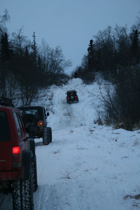 2003 Jeep TJ - Multiple Jeeps navigate a snowy trail during winter off-roading.