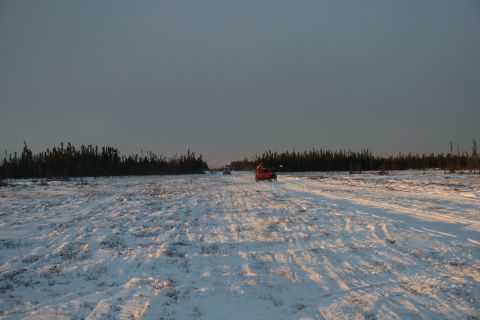 2003 Jeep TJ - Two vehicles travel on a snow-covered path through a forest in winter.