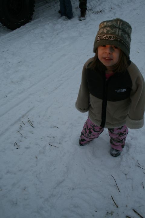 2003 Jeep TJ - A child stands in the snow, with a large tire visible in the background.
