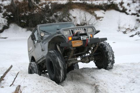 2003 Jeep TJ - Modified Jeep TJ navigating a snowy terrain, likely off-roading.