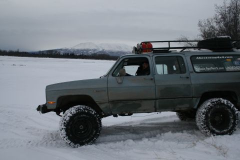 2003 Jeep TJ - SUV navigates snowy terrain with a driver and passenger inside.