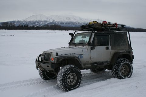 2003 Jeep TJ - A silver 2003 Jeep TJ Rubicon equipped for winter conditions sits in a snowy landscape with mountains in the background.